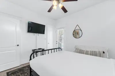 a white bedroom with a bed and a ceiling fan at Panama City Beach House - Sunnyside Up in Panama City Beach