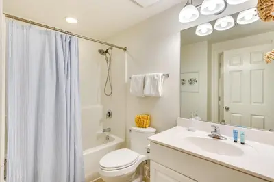 a white bathroom with a sink and a toilet at Gulf Views! 9th-Floor Majestic Beach Resort Condo in Panama City Beach