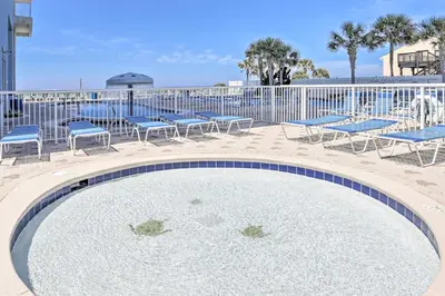 a swimming pool with chairs and tables and a fence at Gulf Views! 9th-Floor Majestic Beach Resort Condo in Panama City Beach