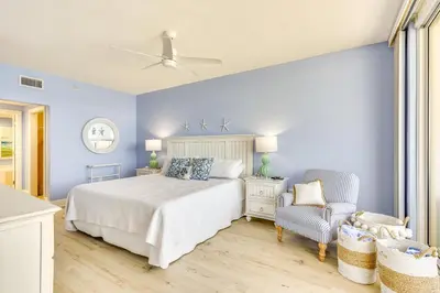 a blue bedroom with a bed and a chair at Gulf Views! 9th-Floor Majestic Beach Resort Condo in Panama City Beach