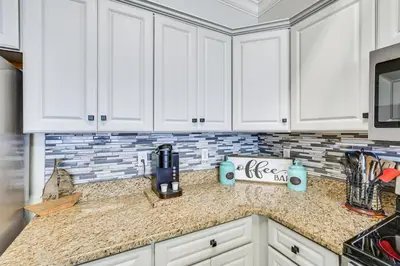a kitchen with white cabinets and a counter top at High-Rise PCB Condo with Oceanfront Views and Pool! in Panama City Beach