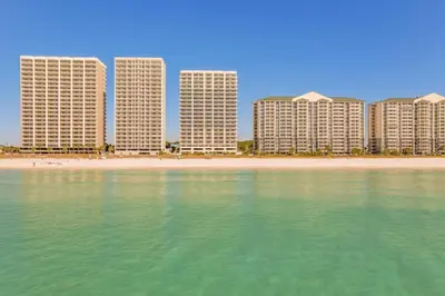a row of tall buildings on a beach next to the water at High-Rise PCB Condo with Oceanfront Views and Pool! in Panama City Beach