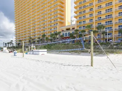 a volley ball net on the beach in front of a hotel at Calypso Beach Resort Towers in Panama City Beach