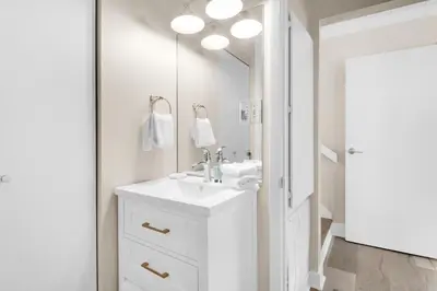 a white bathroom with a sink and a mirror at Double Down in Santa Rosa Beach