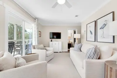 a living room with white furniture and a large window at Double Down in Santa Rosa Beach