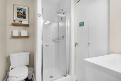 a white bathroom with a shower and a toilet at Double Down in Santa Rosa Beach