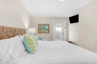 a white bedroom with a white bed with pillows at Double Down in Santa Rosa Beach