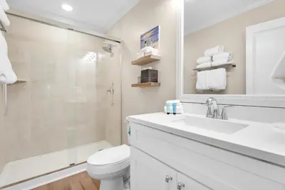 a white bathroom with a sink and a toilet at Double Down in Santa Rosa Beach
