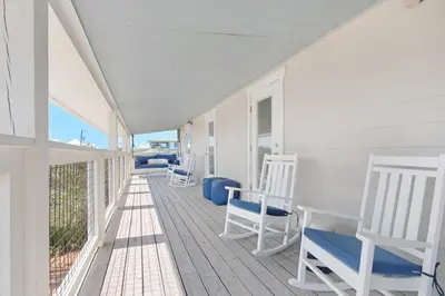 a porch with white rocking chairs on a house at Double Down in Santa Rosa Beach