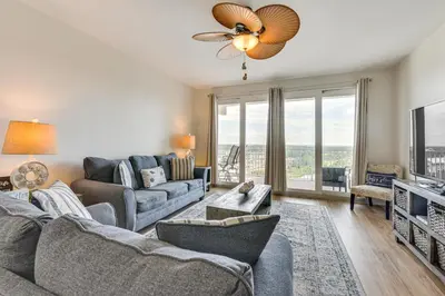 a living room with a couch and a tv at Comfy PCB Condo with View and Private Beach Access! in Panama City Beach