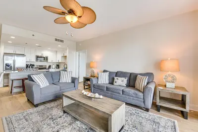 a living room with a couch and a table at Comfy PCB Condo with View and Private Beach Access! in Panama City Beach