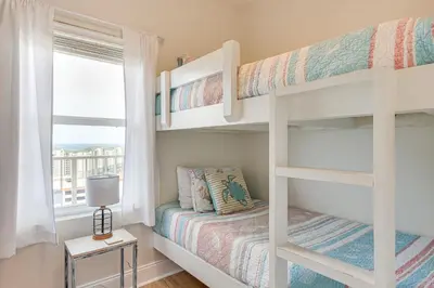 a bedroom with two bunk beds with a window at Comfy PCB Condo with View and Private Beach Access! in Panama City Beach