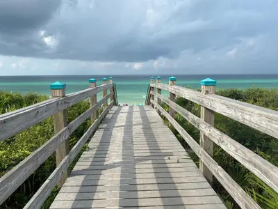 a wooden boardwalk to the beach with the ocean at La Dolce Vita in Inlet Beach