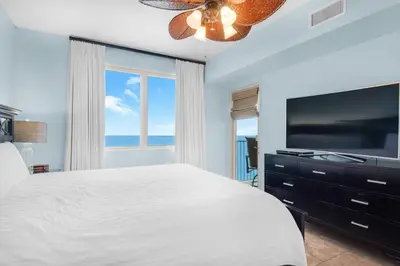 a bedroom with a large bed and a flat screen tv at Shores of Panama 1401 in Panama City Beach