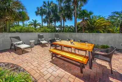 a wooden table and chairs on a brick patio at DRIFTWOOD COTTAGE at Seacrest Beach - 1581803 in Panama City Beach