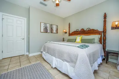 a bedroom with a large bed with a wooden headboard at DRIFTWOOD COTTAGE at Seacrest Beach - 1581803 in Panama City Beach