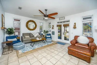a living room with leather furniture and a ceiling fan at DRIFTWOOD COTTAGE at Seacrest Beach - 1581803 in Panama City Beach