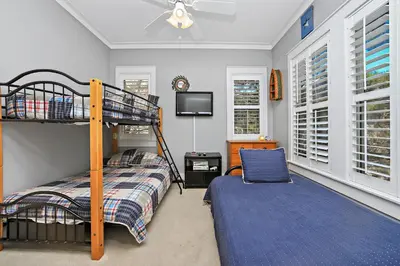 a bedroom with a bunk bed and a tv at Happy Hour - 1232970 in Rosemary Beach