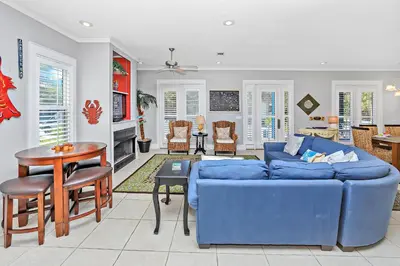 a living room with a blue couch and a table at Happy Hour - 1232970 in Rosemary Beach