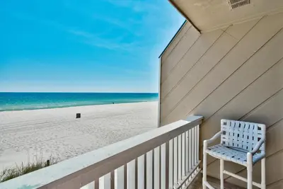 a white chair sitting on a balcony overlooking the beach at Pirate Cove Villa 117 - 825255 in Panama City Beach