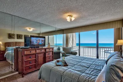 a bedroom with a bed and a television and a balcony at Pirate Cove Villa 117 - 825255 in Panama City Beach