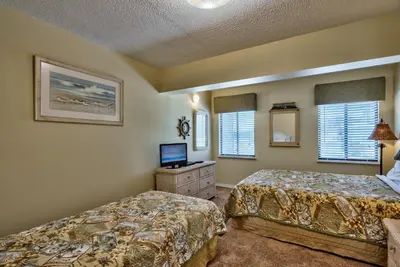 a bedroom with two beds and a television in it at Pirate Cove Villa 117 - 825255 in Panama City Beach