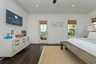 a white bedroom with a bed and a dresser at Seas The Day at Seacrest - 1228999 in Panama City Beach