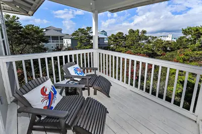 a porch with two chairs and a table at Seas The Day at Seacrest - 1228999 in Panama City Beach
