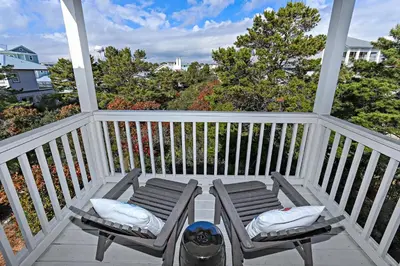 a porch with two chairs and a backpack at Seas The Day at Seacrest - 1228999 in Panama City Beach