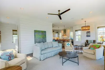 a living room with couches and a ceiling fan at The White House - 1232985 in Santa Rosa Beach