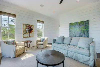 a living room with a couch and a table at The White House - 1232985 in Santa Rosa Beach