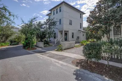 a white house with a driveway in front of it at The White House - 1232985 in Santa Rosa Beach