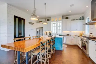 a large kitchen with a wooden table and chairs at The White House - 1232985 in Santa Rosa Beach