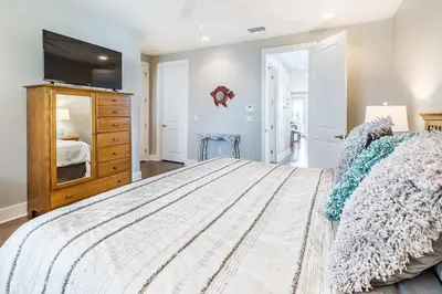 a bedroom with a large bed and a flat screen tv at Inn to the Mystic in Santa Rosa Beach