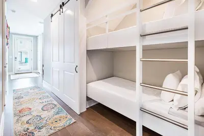 a white closet with white shelves and a rug at Inn to the Mystic in Santa Rosa Beach