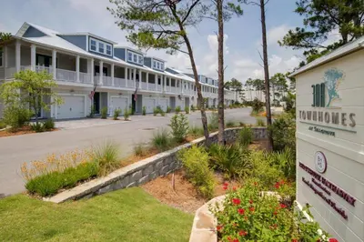 a building with a sign in front of a street at Inn to the Mystic in Santa Rosa Beach