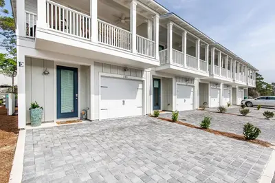 a large white house with a driveway at Inn to the Mystic in Santa Rosa Beach