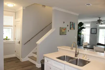 a kitchen with a sink and a staircase at Beach Beyond Belief House & private pool & free bikes & private beach in Rosemary Beach
