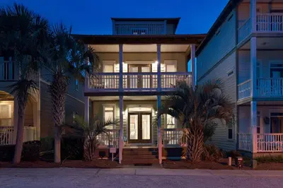 a building with palm trees in front of it at Beach Beyond Belief House & private pool & free bikes & private beach in Rosemary Beach