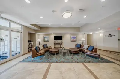 a lobby with couches and a table and a tv at Candlewood Suites - Panama City Beach Pier Park by IHG in Panama City Beach