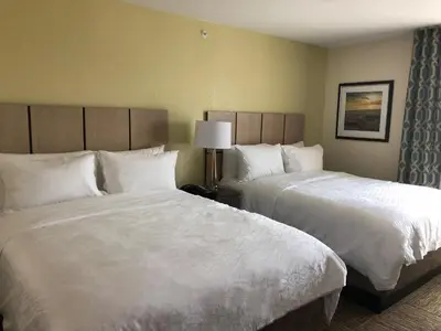two beds in a hotel room with white sheets at Candlewood Suites - Panama City Beach Pier Park by IHG in Panama City Beach