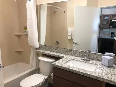 a bathroom with a toilet and a sink and a tub at Candlewood Suites - Panama City Beach Pier Park by IHG in Panama City Beach