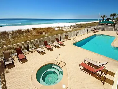 a swimming pool with lounge chairs and the beach at Ocean Ritz 1902 in Panama City Beach