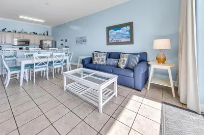 a living room with a blue couch and a table at Ocean Ritz 1902 in Panama City Beach