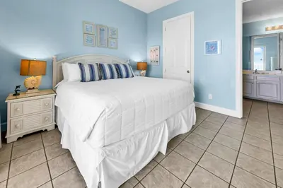 a bedroom with a large white bed and blue walls at Ocean Ritz 1902 in Panama City Beach