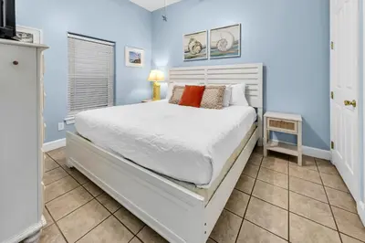 a bedroom with a white bed and blue walls at Ocean Ritz 1902 in Panama City Beach