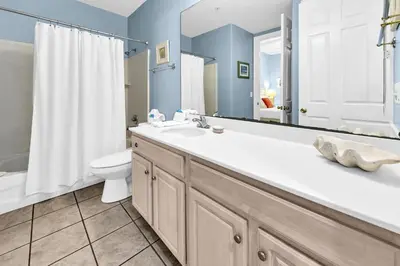 a bathroom with a tub and a sink and a toilet at Ocean Ritz 1902 in Panama City Beach