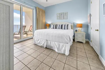 a bedroom with a bed and a balcony at Ocean Ritz 1902 in Panama City Beach