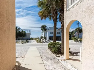 a street with palm trees and a building at Merrimac Resort #32 in Panama City Beach