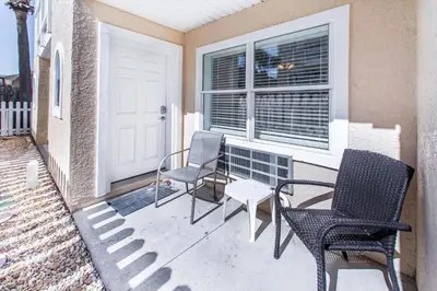 a porch with two chairs and a window at Merrimac Resort #32 in Panama City Beach